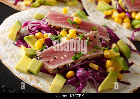 Fisch Tacos mit Thunfisch, Rotkohl, Mais, Avocado und Zwiebeln auf dem Tisch. Horizontale Stockfoto