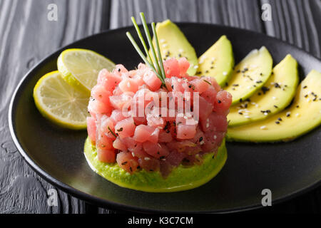 Zahnstein von frischen, rohen Thunfisch mit Gewürzen close-up auf einem Teller. Horizontale Stockfoto