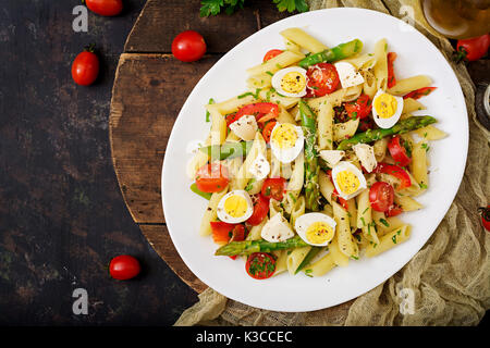 Salat - penne Nudeln mit Spargel, Tomaten, Wachteleier, Mozzarella Stockfoto