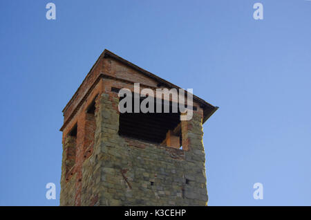Historischen italienischen Turm aus Stein und Ziegel mit Holzverkleidung, Kopfsteinpflaster und embrisa. Stockfoto