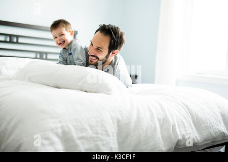 Vater und Sohn im Bett, glückliche Zeit auf dem Bett Stockfoto