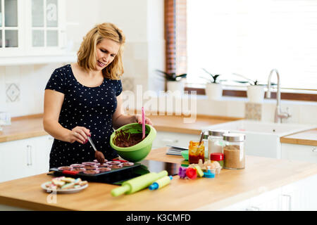 Schöne schwangere Frau Vorbereitung Muffins Stockfoto