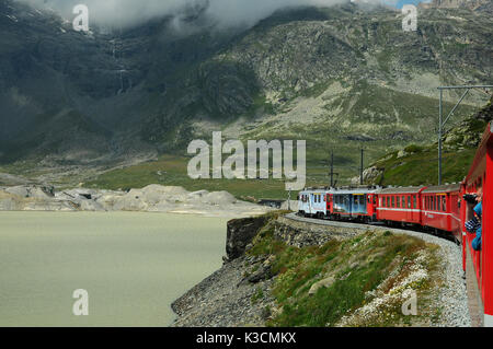 Berühmte rote alpine Zug Bernina Express von St. Moritz nach Tirano, vorbei an den Blanc See am Bernina Pass in der Schweiz Stockfoto