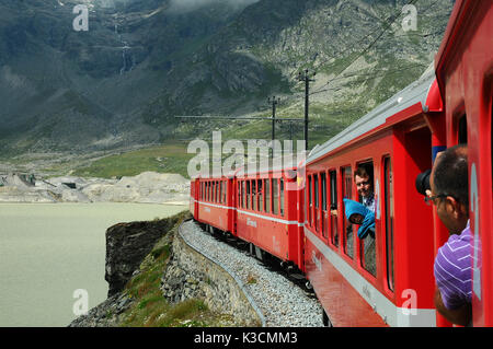 Berühmte rote alpine Zug Bernina Express von St. Moritz nach Tirano, vorbei an den Blanc See am Bernina Pass in der Schweiz Stockfoto