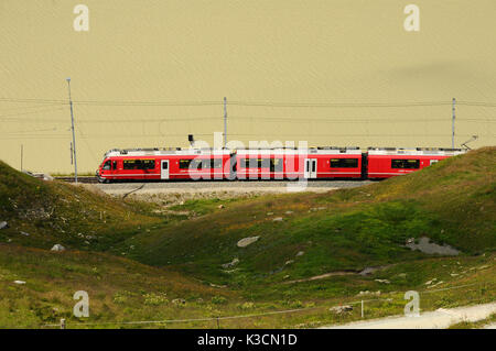 Berühmte rote alpine Zug Bernina Express von St. Moritz nach Tirano, vorbei an den Blanc See am Bernina Pass in der Schweiz Stockfoto