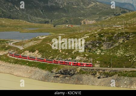 Berühmte rote alpine Zug Bernina Express von St. Moritz nach Tirano, vorbei an den Blanc See am Bernina Pass in der Schweiz Stockfoto