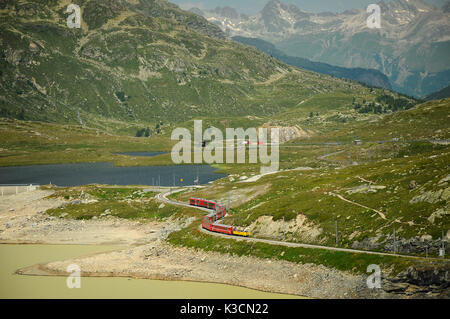 Berühmte rote alpine Zug Bernina Express von St. Moritz nach Tirano, vorbei an den Blanc See am Bernina Pass in der Schweiz Stockfoto