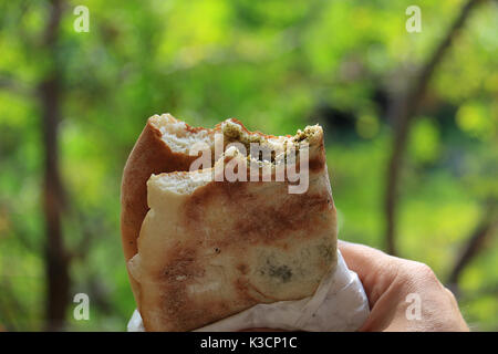 Ein Mann hält eine traditionelle libanesische Küche Frühstück, mankousheh. Stockfoto