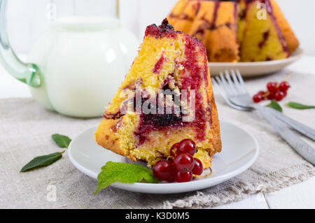 Ein großes Stück Cottage Cheese Cake mit Sommer Beeren und Konfitüre auf weißem Hintergrund. Stockfoto