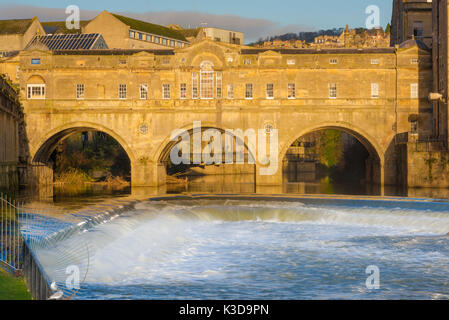 Bath Bridge UK, Blick auf die von Robert Adam entworfene Pulteney Bridge in Bath mit der Stadt Wehr am Fluss Avon im Vordergrund, UK Stockfoto