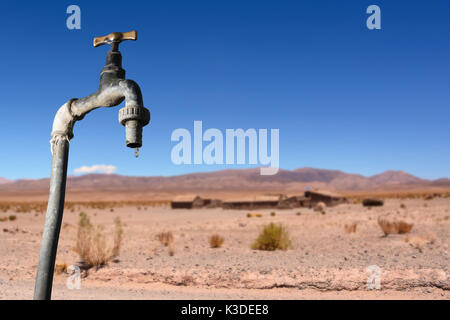 Der Wasserhahn tropft und trockenen Umgebung im Hintergrund Stockfoto