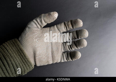 Isolierte abgenutzt Arbeitshandschuhe gegen eine schwarze Oberfläche Stockfoto