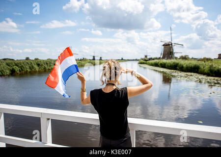 Die Frau in der Nähe der alten Windmühlen in den Niederlanden Stockfoto
