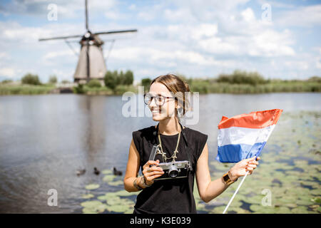 Die Frau in der Nähe der alten Windmühlen in den Niederlanden Stockfoto