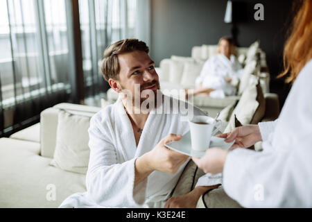 Schöner Mann glücklich nach Erhalt Tee am Morgen Stockfoto