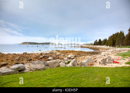 Holz- Adirondack Stühle auf felsigen Ufern von Nova Scotia, Kanada an einem sonnigen Tag. Stockfoto