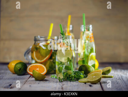 Zitronenwasser mit frischen Zitronen, Limetten und Minzeblättchen Stockfoto