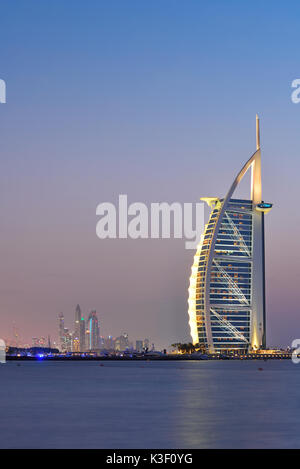 Dubai, Vereinigte Arabische Emirate - 10.Oktober 2016: Die beleuchteten Burj Al Arab Hinweis und in der Abenddämmerung marinal, Ansicht von Jumeira Beach, nach Südwesten. Stockfoto