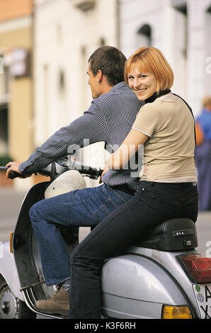 Junge Paare auf Vespa Motorroller. Frau schaut über die Schulter. Stockfoto