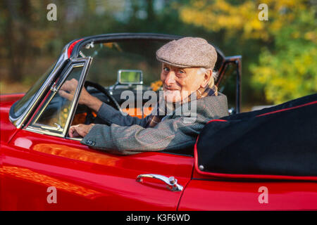 Senior sitzt in Red Old-timer Jaguar Cabrio Stockfoto