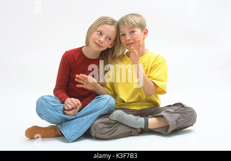 Mädchen und Jungen Kreuz sitzen im Schneidersitz Stockfoto