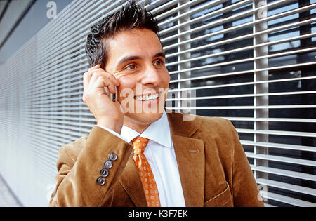 Junger Mann Telefone außerhalb Mobile Stockfoto