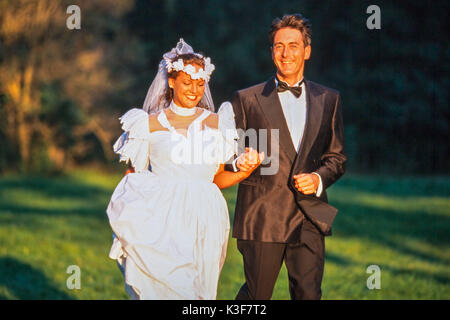 Braut und Bräutigam läuft Hand in Hand über einer Wiese Stockfoto