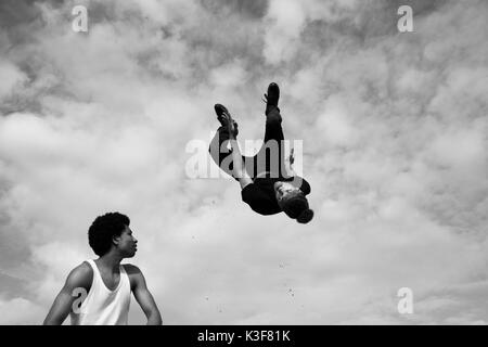 Jungen Erwachsenen Mannes spiegeln Upside Down in Luft Stockfoto