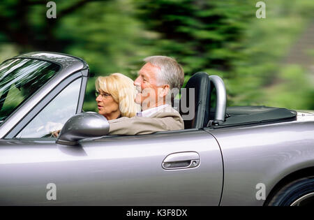Paar in Silber Cabrio Stockfoto