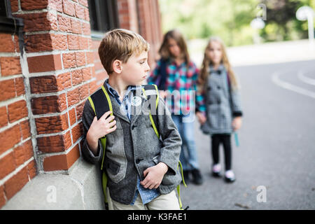 Schüler Freunde necken ein Schüler allein Grundschule Stockfoto