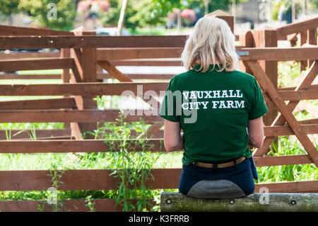 Ein Arbeitnehmer, der an der Vauxhall Stadt Hof im Süden Londons mit dem Namen der Farm auf Ihr Shirt Stockfoto