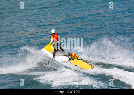 Bournemouth, Dorset, Großbritannien. September 2017. UK Wetter: Schöner warmer sonniger Tag am Bournemouth Strand. RNLI Rettungsschwimmer auf Jetski mit Leben im Meer - Rückansicht, Rückansicht. Jetskifahrer Jetskifahrer Jetski Jetski Jetski Jetski Jetski Jetski Jetski Jetskifahrer Jetskifahrer Jetski Jetski Jetski. Quelle: Carolyn Jenkins/Alamy Live News Stockfoto