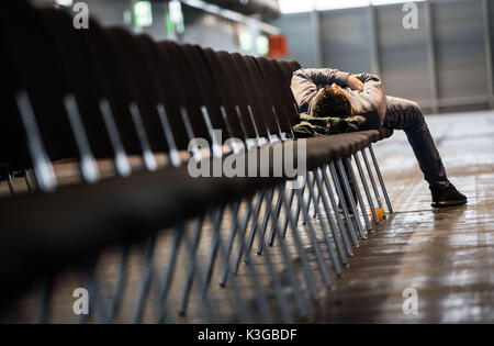 Ein Mann hält ein Nickerchen auf der Messe Halle 1 nach in seinem Haus in der evakuierungszone zu verlassen heute Morgen in Frankfurt am Main, Deutschland, 3. September 2017. Bis zu 70.000 Menschen haben ihre Häuser aufgrund eines WWII Antenne landmine - erwartet die größte Evakuierung in Deutschland seit dem Krieg zu verlassen. Foto: Frank Rumpenhorst/dpa Stockfoto