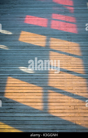 Bunte Muster, die von der Sonne durch Glasfenster shining verursacht, auf der Terrasse in Worthing Pier in West Sussex, England. Stockfoto
