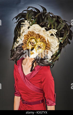 Eine schöne, junge Mädchen mit einem Venezianische Maske in einem Studio Stockfoto