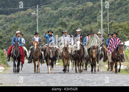 Mai 27, 2017 Sangolqui, Ecuador: Eine Gruppe von Cowboys reiten ihre Pferde auf einer Landstraße in Richtung einer ländlichen Rodeo in den Anden Stockfoto