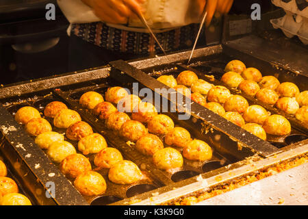 Japan, Hoshu, Tokio, Koch, Takoyaki (Teig und Octopus Bälle) Stockfoto