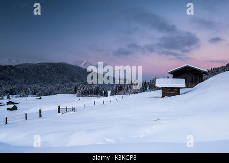 Zwei Scheunen in der Weiler Gerold während der winterlichen Sonnenaufgang. Im Hintergrund befindet sich die Zugspitze. Stockfoto