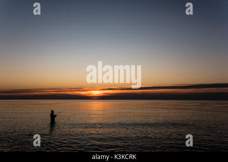 Angler mit Angel in das Wasser der Ostsee mit Wustrow und Fischen auf Meerforelle. Stockfoto