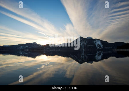 Die Spiegelung in den Walchensee. Sonnenuntergang und spezielle wolkenbildung sind in den Walchensee vor der Silhouette der Herzogstand und Simetsberg wider. Stockfoto