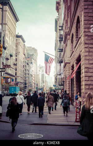 Typische NY Straßenbild, Amerika Flagge, beschäftigt die Menschen und den Verkehr auf der 5th Ave, Manhatten, New York, USA Stockfoto