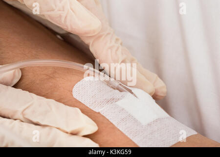 In der Nähe des Doctor's Hand mit Infusion eingefügt in die Hand des Patienten Stockfoto