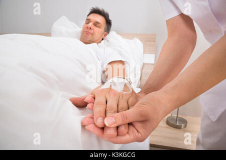 In der Nähe des Doctor's Hand mit Infusion eingefügt in die Hand des Patienten Stockfoto