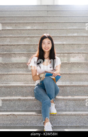 Mädchen sitzen Studenten auf der Treppe mit Büchern smlie Stockfoto