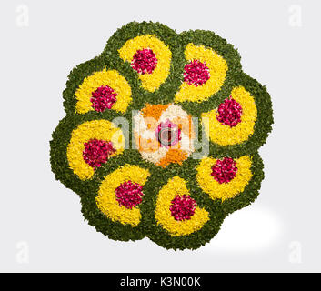 Blume rangoli für Diwali oder pongal oder onam mit Ringelblume oder zendu Blumen und roten Rosenblättern über weißen Hintergrund mit diwali Diya Stockfoto