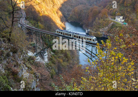 Panorama-zug Zug fährt über eine Brücke in der Nähe von Borgnone bei Sonnenuntergang, Kanton Tessin, Schweiz. Stockfoto