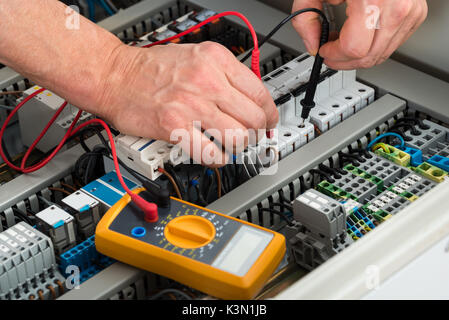 Nahaufnahme eines männlichen Elektriker Prüfen der Sicherung mit Multimeter Stockfoto