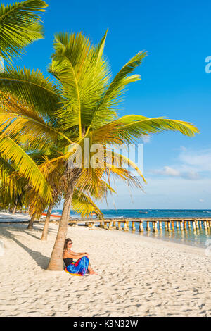 Mano Juan, Saona, East National Park (Parque Nacional del Este), Dominikanische Republik, Karibik. Frau entspannend auf den palmengesäumten Strand (MR). Stockfoto