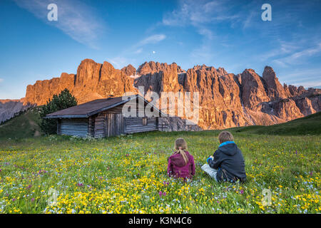 Passo Gardena, Dolomiten, Südtirol, Italien. Kinder bewundern Sie die alpenglühen auf die Berge der Sella Stockfoto