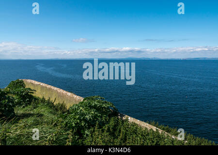 Blick nach Westen von fidra Island Lighthouse über Firth von weiter an einem sonnigen Tag und an der Wand des alten Leuchtturmwärters Garten im Vordergrund Stockfoto